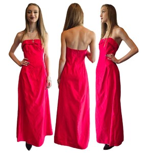 May include: A strapless, floor-length, bright red dress with a fitted bodice and a flowing skirt.