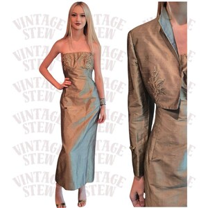May include: A vintage, floor-length, strapless gown in a shimmering, muted gold and green color. The bodice features embroidered detailing. A matching bolero jacket with long sleeves and embroidered accents completes the ensemble. The dress is a formal wear item.