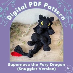 May include: A black crocheted dragon toy with yellow eyes and red tail accents. The dragon is lying on a wooden surface. The image includes the text "Digital PDF Pattern" and "Supernova the Fury Dragon (Snuggler Version)".