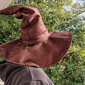 Tovenarij en tovenarijbeker. Chapeau pointu. Halloween. Cosplayen. Magische Chapeau. Chapeau voor het marcheren in het bos.