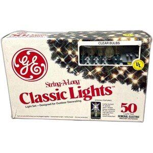 May include: A box of General Electric String-A-Long Classic Lights, designed for indoor/outdoor decorating. The box features the GE logo and text that reads "Clear Bulbs" and "50 Light Set". The box also shows a picture of the lights.