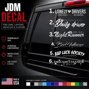 Puede incluir: Una colección de seis calcomanías de vinilo blanco estilo JDM mostradas en la ventana de un vehículo negro. Las opciones de texto incluyen Lonely Drivers, Daily Driver, Night Runner, Bad Influence, Bad Luck Society y Dream Chaser.