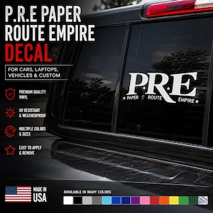 以下が含まれることがあります： 車両の窓に貼られた、星と「P.R.E PAPER ROUTE EMPIRE」の文字がデザインされた白いビニール製デカール。大きなフォントの「P.R.E」の文字の下に「PAPER ROUTE EMPIRE」という言葉が配置されており、車やノートパソコン向けにデザインされています。