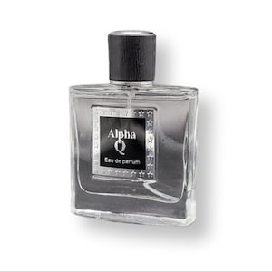 Puede incluir: Una botella de vidrio transparente de Alpha Q Eau de Parfum con una tapa negra y una etiqueta plateada con un diseño de estrellas.