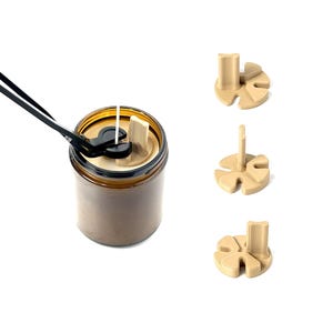 May include: A set of three brown candle holders with a black metal tool. The candle holders are shaped like a flower with five petals. The tool is used to center the wick in the candle.