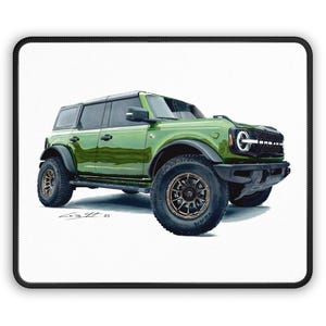 May include: A green Ford Bronco SUV illustration on a white background. The vehicle has black accents, bronze-colored wheels, and a black roof. The image is on a mousepad with a black border.