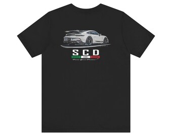 Puede incluir: Camiseta negra con un gráfico de coche deportivo blanco. El diseño incluye las letras "SCD" sobre una franja verde, blanca y roja, y las palabras "Draw Your Dreams". Una camiseta elegante para los entusiastas de los coches.