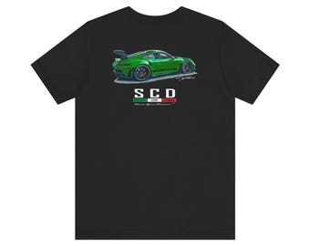 May include: Black t-shirt featuring a green sports car illustration. The car has a spoiler and black wheels. Below the car is the text "SCD" with a green, white, and red stripe design.