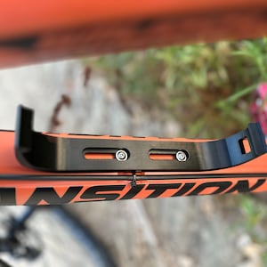 Top view of audio speaker mounting bracket showing screws tightened to bicycle frame.