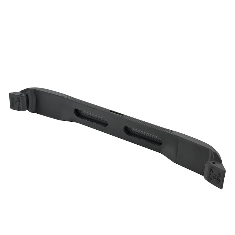 May include: A black plastic bar with a curved design and several rectangular cutouts. The ends of the bar have a raised section with the text "PRESS TO RELEASE".