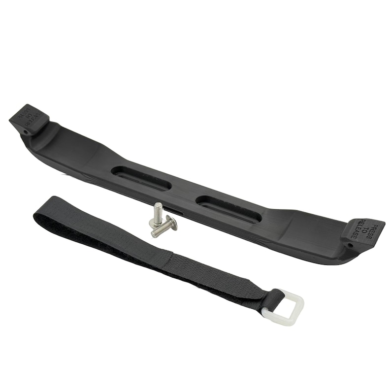 May include: A black battery hold-down strap with a matching base, a black strap with a white buckle, and two silver screws. The base has the text "PRESS TO RELEASE" and "EXPAND TO RELEASE".