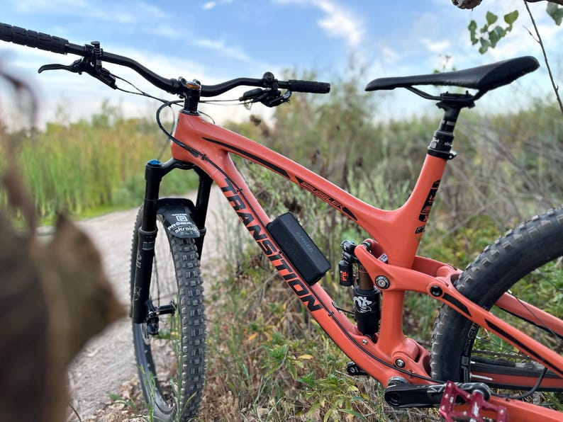 Transition smuggler mountain bike with Bluetooth speaker mounted to it for listening to music