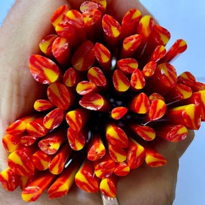 May include: A bunch of red and yellow glass rods with a striped pattern. The rods are approximately 1/4 inch in diameter.