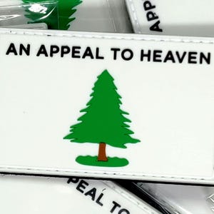 May include: White patch with a green pine tree and the text "An Appeal to Heaven" in black.