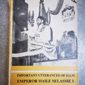 May include: A yellow book with the title "IMPORTANT UTTERANCES OF H.I.M EMPEROR HAILE SELASSIE I" and a black and white photo of a man in a suit speaking at a podium.