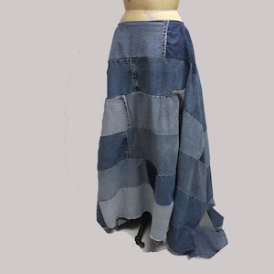 May include: A patchwork denim skirt in various shades of blue. The skirt is made from rectangular pieces of denim sewn together, creating a unique, textured design. The skirt has a high waist and a flowing, full length.