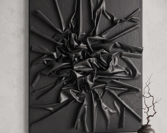 May include: A square black wall art piece featuring a central cluster of gathered, folded fabric-like material that radiates outward toward the edges of the frame, creating a three-dimensional, textured surface with deep shadows and highlights.