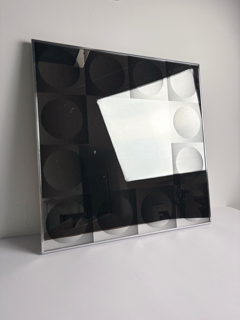 Square optical art wall mirror with graphic monochrome design and chrome frame, collectible 1970s design piece