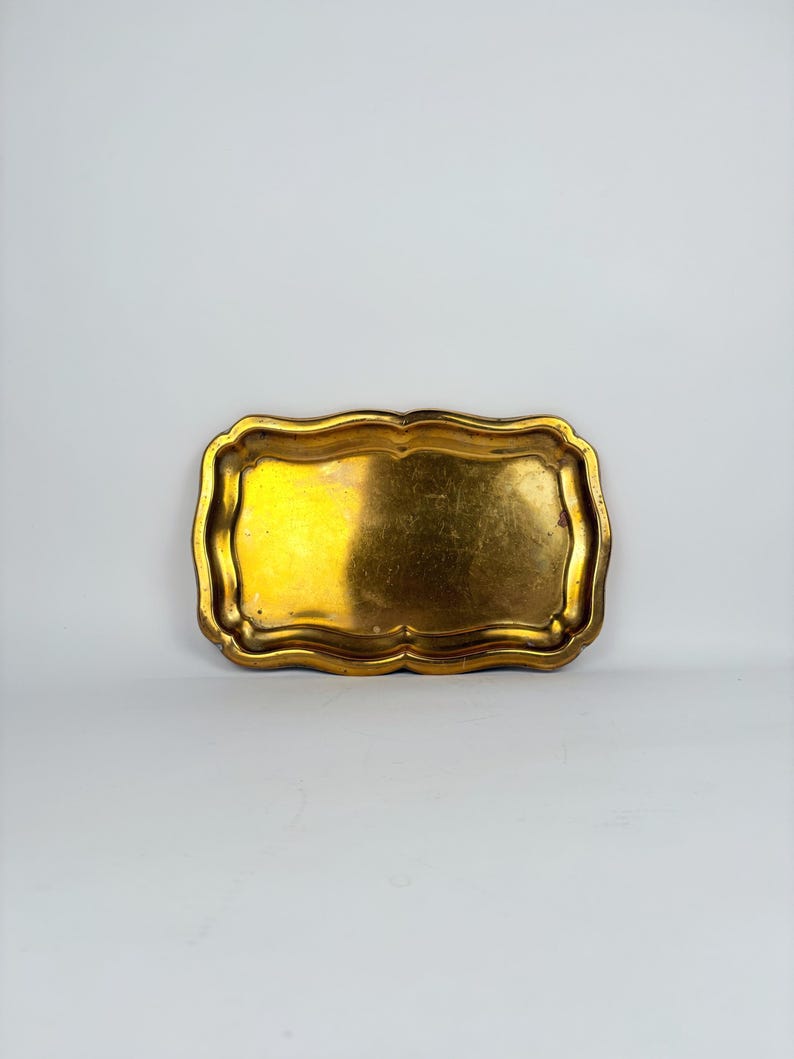 Small vintage brass tray with curved edges, shown on a light background ideal as a jewelry dish, key holder, or vanity tray.