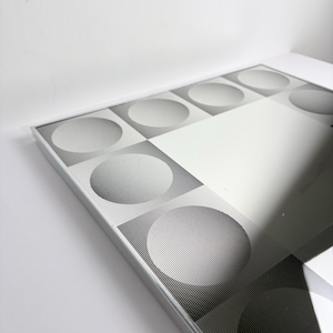 Mid century modern Op Art mirror featuring geometric illusion pattern and reflective center, retro wall decoration