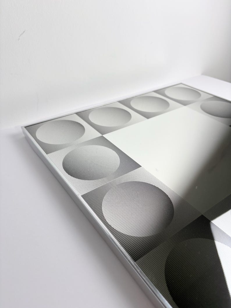 Mid century modern Op Art mirror featuring geometric illusion pattern and reflective center, retro wall decoration