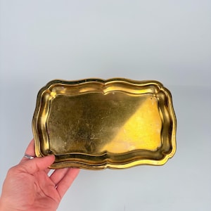 Small vintage brass tray with curved edges, shown on a light background – ideal as a jewelry dish, key holder, or vanity tray.
