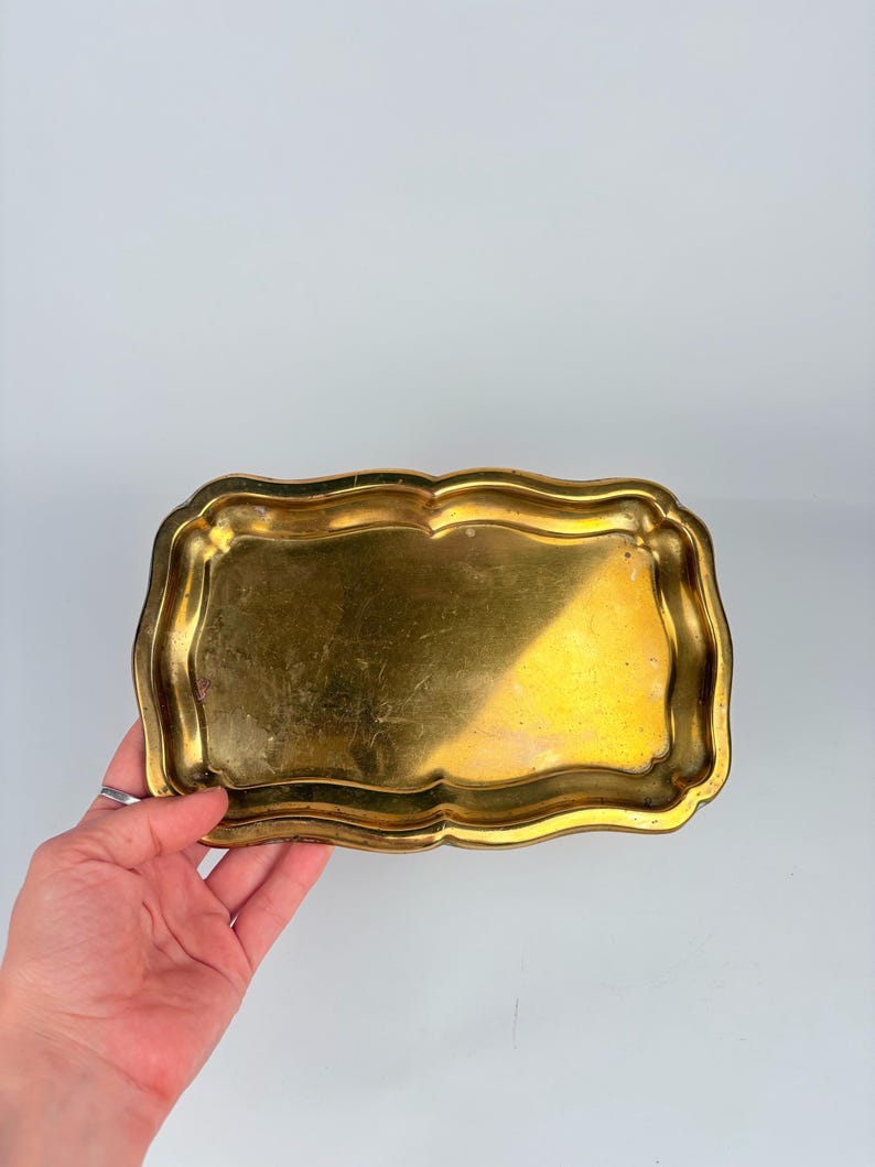 Small vintage brass tray with curved edges, shown on a light background – ideal as a jewelry dish, key holder, or vanity tray.