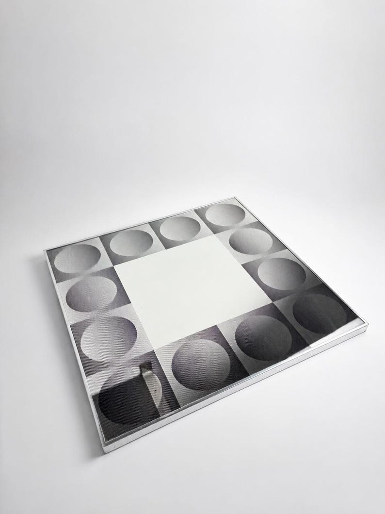 Retro optical illusion mirror with monochrome geometric design, sculptural wall accent from the 1970s