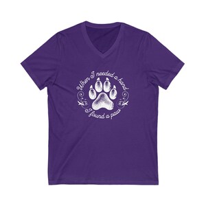 May include: Purple V-neck t-shirt with a white paw print graphic and the text "When I needed a hand I found a paw".