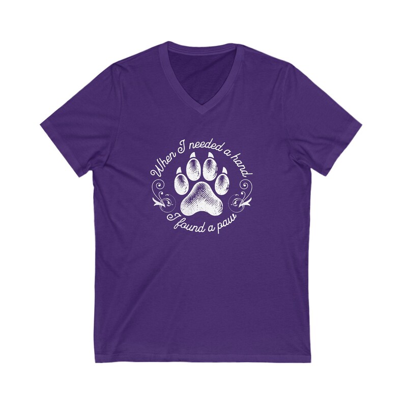 May include: Purple V-neck t-shirt with a white paw print graphic and the text "When I needed a hand I found a paw".
