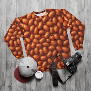 May include: A brown sweatshirt with a pattern of baked beans in a tomato sauce. The sweatshirt has long sleeves and a crew neck.