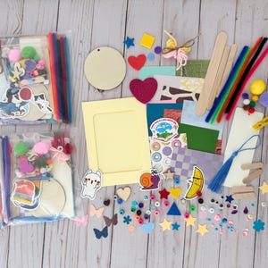 May include: A craft kit with a variety of colorful supplies, including felt shapes, wooden circles, pipe cleaners, stickers, and googly eyes. The kit also includes a blank card and a frame.