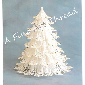 Puede incluir: Un árbol de Navidad blanco tejido a ganchillo, con múltiples niveles, adornado con pequeñas cuentas doradas. El árbol tiene una punta afilada y está sobre un fondo azul claro. El texto en la imagen dice "A Fine Art Thread."