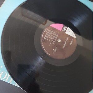 Puede incluir: Un disco de vinilo negro de Fats Domino, etiquetado como "STEREO". El disco es parcialmente visible, descansando sobre una portada de &aacute;lbum azul claro. La portada del &aacute;lbum tiene el texto "Fats Domino" y otros textos.