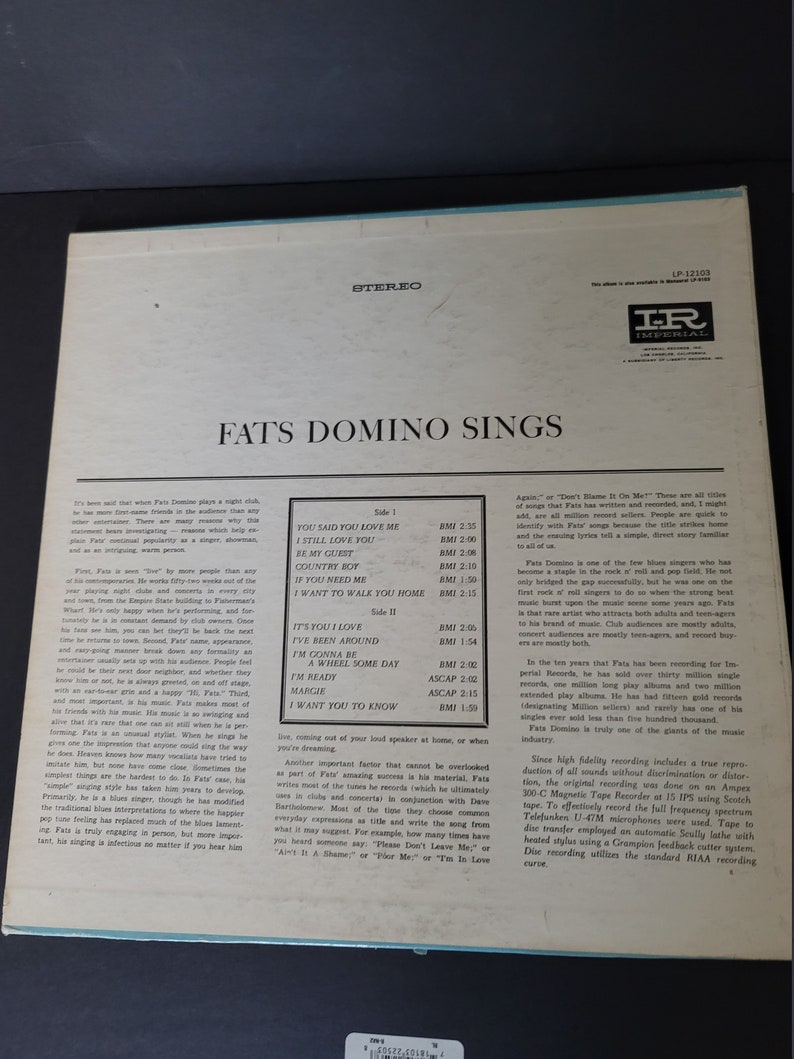 Puede incluir: Portada de &aacute;lbum de vinilo LP vintage "Fats Domino Sings". La portada del &aacute;lbum es blanquecina con texto negro y un borde azul claro. El &aacute;lbum presenta una lista de canciones en la parte posterior.
