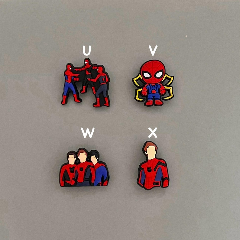 Puede incluir: Cuatro encantos diferentes con personajes de Spider-Man. El primer encanto muestra tres figuras de Spider-Man en una pose de lucha. El segundo encanto muestra una sola figura de Spider-Man con un dise&ntilde;o de telara&ntilde;a. El tercer encanto muestra tres figuras de Spider-Man de pie juntas. El cuarto encanto muestra una sola figura de Spider-Man de pie con los brazos cruzados.