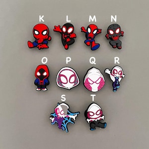 Puede incluir: Diez charms diferentes para zapatos con personajes de Spider-Man. Los charms est&aacute;n hechos de goma y presentan diferentes poses de Spider-Man y Spider-Gwen. Los charms est&aacute;n etiquetados con letras de la K a la T.
