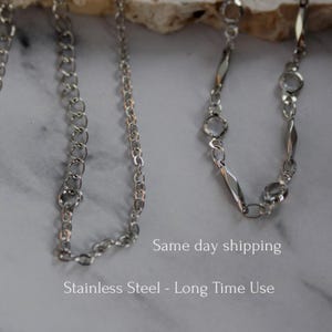 May include: Two silver-toned metal chains. The left chain features uniform circular links. The right chain alternates between elongated diamond-shaped links and small circular links. The text "Same day shipping" and "Stainless Steel - Long Time Use" is visible.