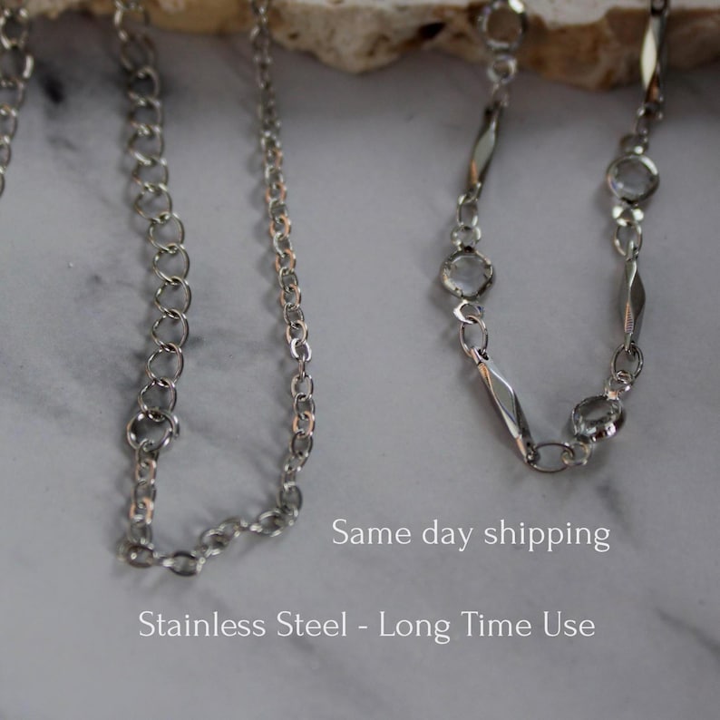 May include: Two silver-toned metal chains. The left chain features uniform circular links. The right chain alternates between elongated diamond-shaped links and small circular links. The text "Same day shipping" and "Stainless Steel - Long Time Use" is visible.