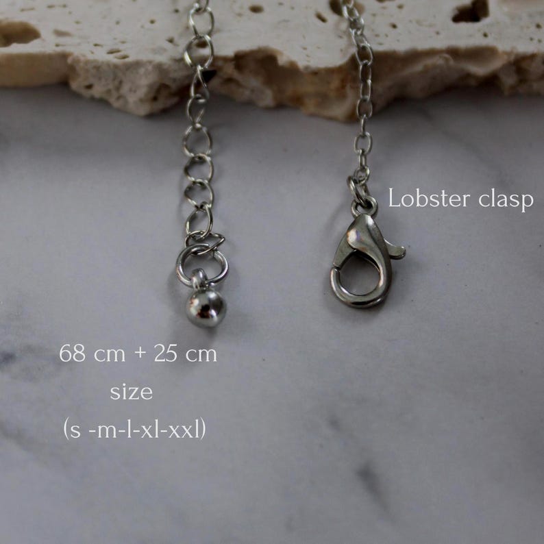May include: A silver-toned metal chain necklace component featuring a lobster clasp and an extender chain ending in a small spherical bead. The text on the image indicates a length of 68 cm + 25 cm and sizes ranging from s-m-l-xl-xxl.