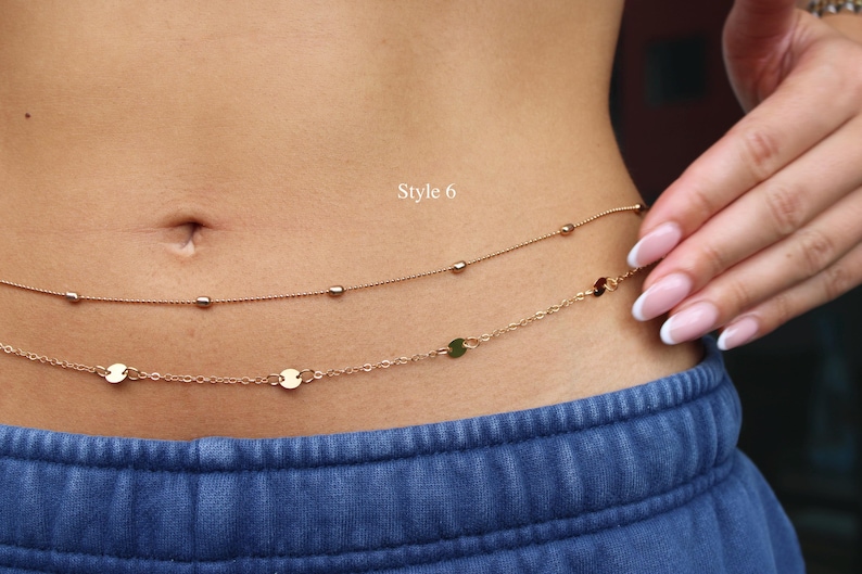 May include: A double-strand rose gold waist chain featuring one delicate chain with small beads and a second chain with flat circular discs. The text Style 6 is visible above the chains, which are worn around the midsection over blue pants.