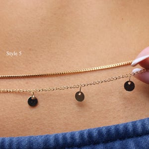 May include: A gold-toned double-strand chain necklace or waist chain featuring a smooth, solid chain and a second chain adorned with four small, circular, flat disc charms hanging at intervals. The text Style 5 is visible on the left side.