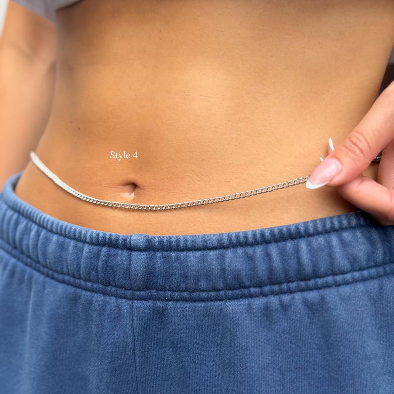 May include: A thin silver-colored metal chain worn around the waist, featuring small interlocking links. The text Style 4 is printed in white above the chain. The chain is positioned horizontally across the midsection above blue sweatpants.