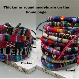 Puede incluir: Dos pilas de pulseras tejidas de colores. La pila de la izquierda es m&aacute;s gruesa y la pila de la derecha es redonda. El texto "Thicker" est&aacute; debajo de la pila de la izquierda y el texto "Round" est&aacute; debajo de la pila de la derecha. El texto "Thicker or round models are on the home page" est&aacute; en la parte superior de la imagen.