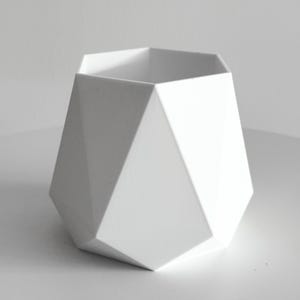 May include: A white, geometric planter with a faceted design. The planter has a wide opening and a series of angled, flat sides. The minimalist design is suitable for modern home decor.