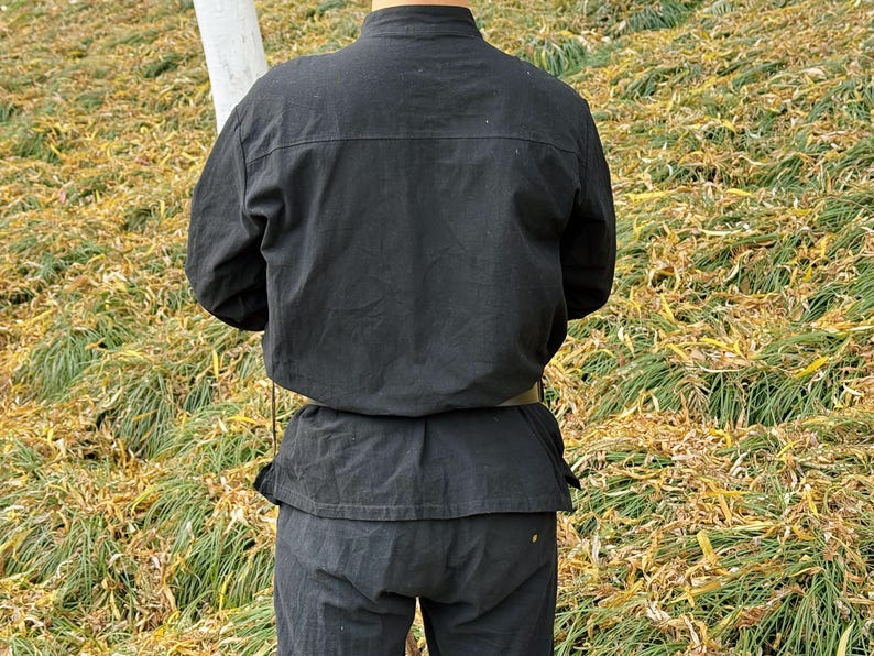May include: A black long-sleeved shirt with a mandarin collar and a belt. The shirt is made of a soft, comfortable fabric and has a relaxed fit.