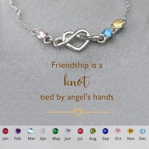 May include: A silver infinity heart charm bracelet with colourful gemstones. The bracelet has a quote that reads "Friendship is a knot tied by angel's hands".