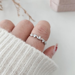 Puede incluir: Un anillo de plata con un delicado dise&ntilde;o de vid y peque&ntilde;as piedras transparentes.