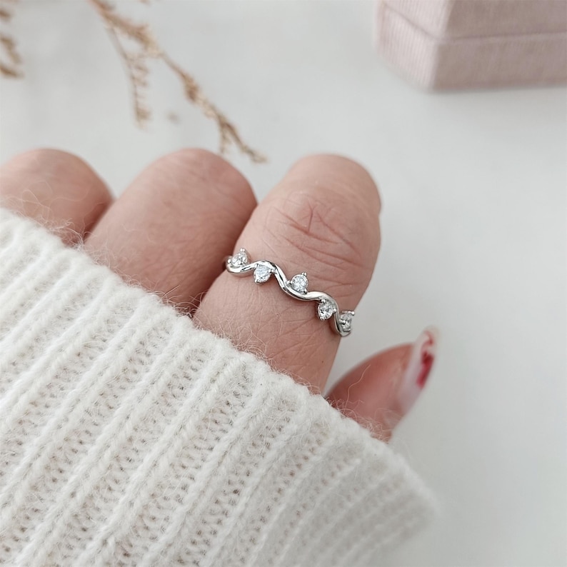 Puede incluir: Un anillo de plata con un delicado dise&ntilde;o de vid y peque&ntilde;as piedras transparentes.