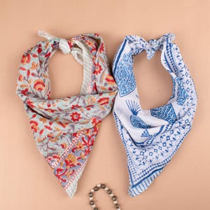 May include: Two cotton bandanas, one with a floral pattern in shades of blue, red, and green, and the other with a blue and white peacock design.